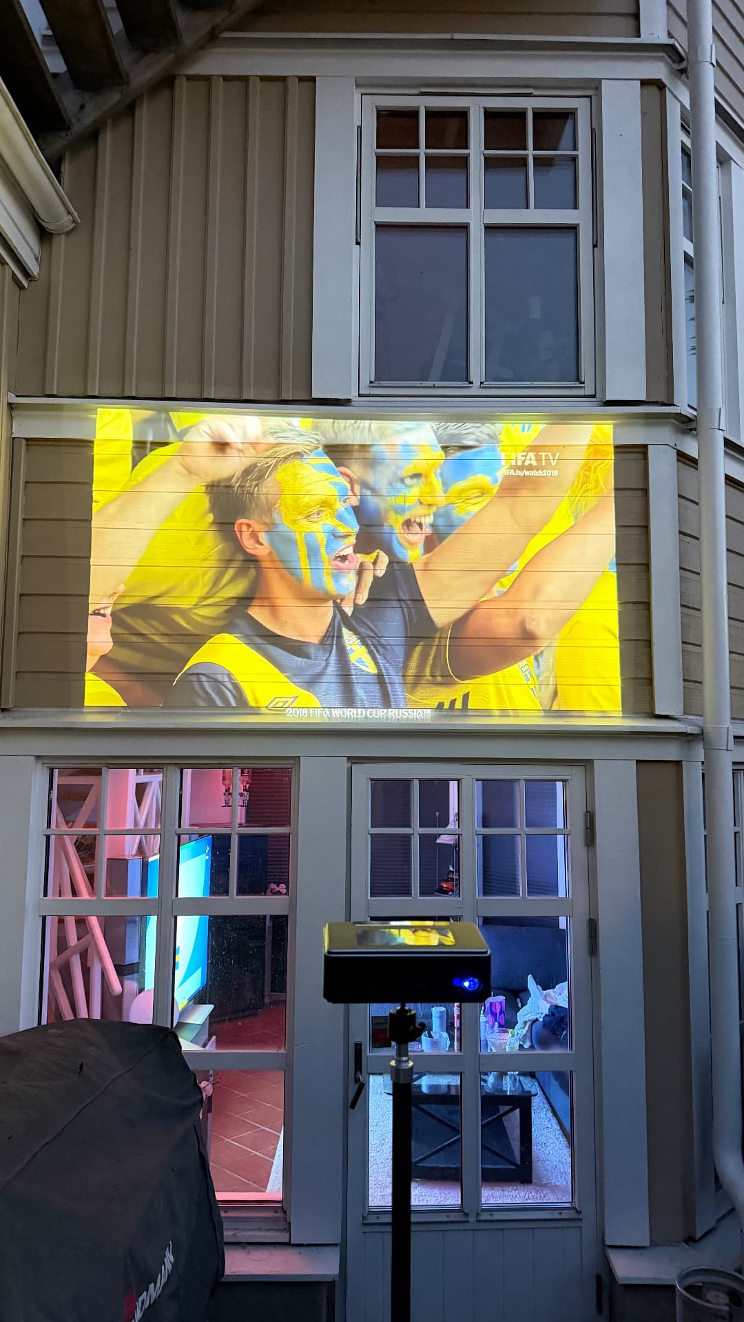 Fotboll projicerad på en husvägg utomhus med PICZO Nova Ultra S på stativ