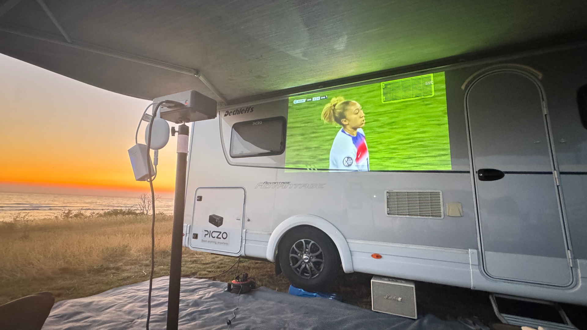 PICZO Nova Ultra S projicerar fotboll på husbil i solnedgång