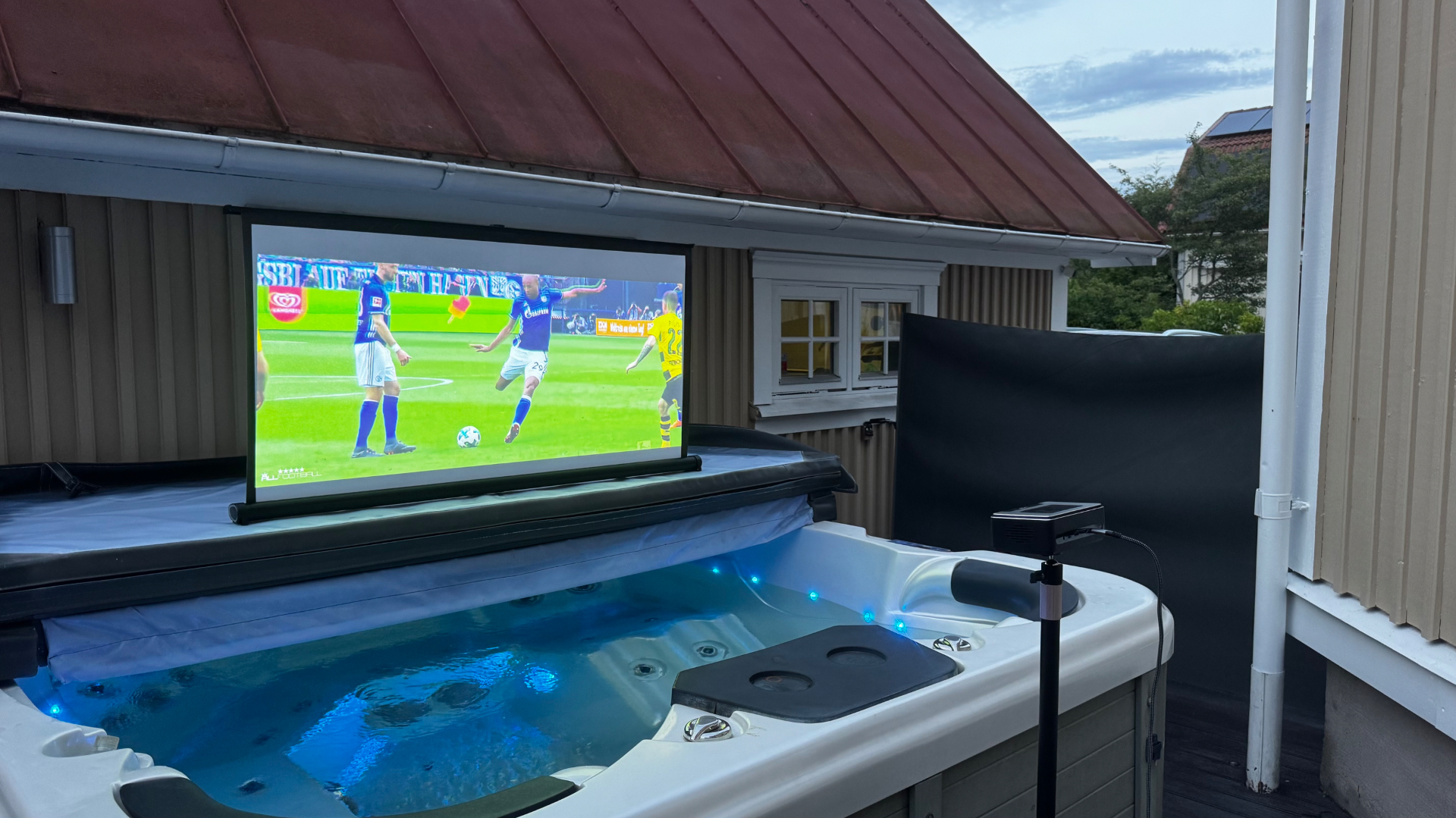 PICZO Nova Ultra S projicerar fotboll på duk ovanför ett utomhusspa i skymning